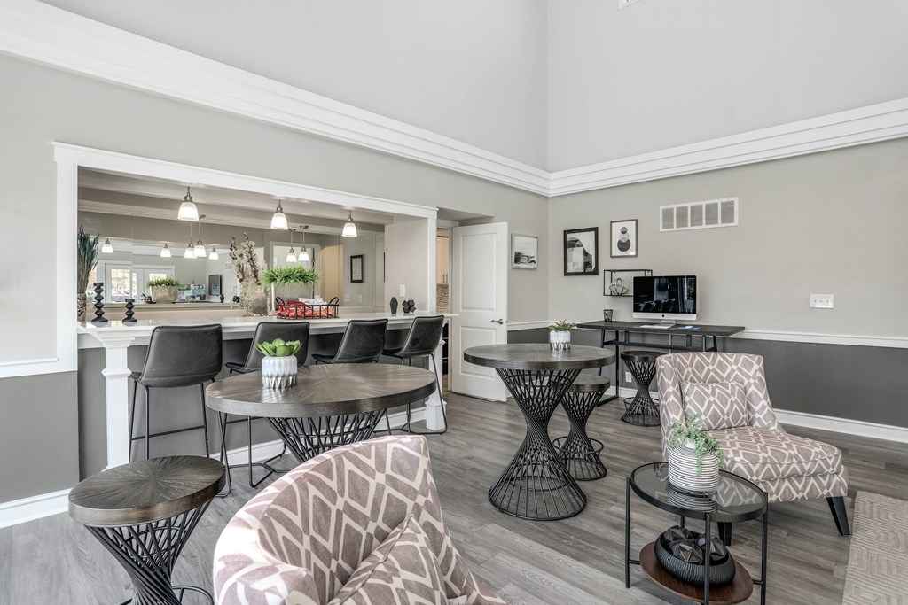 an open living room with tables and chairs and a kitchen