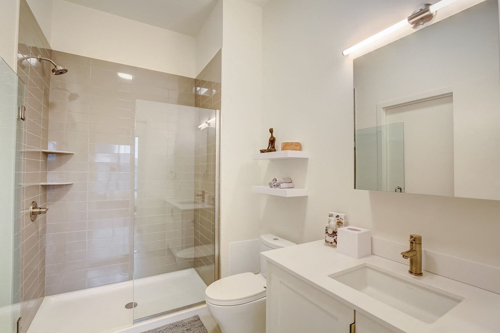 a white bathroom with a shower sink and toilet
