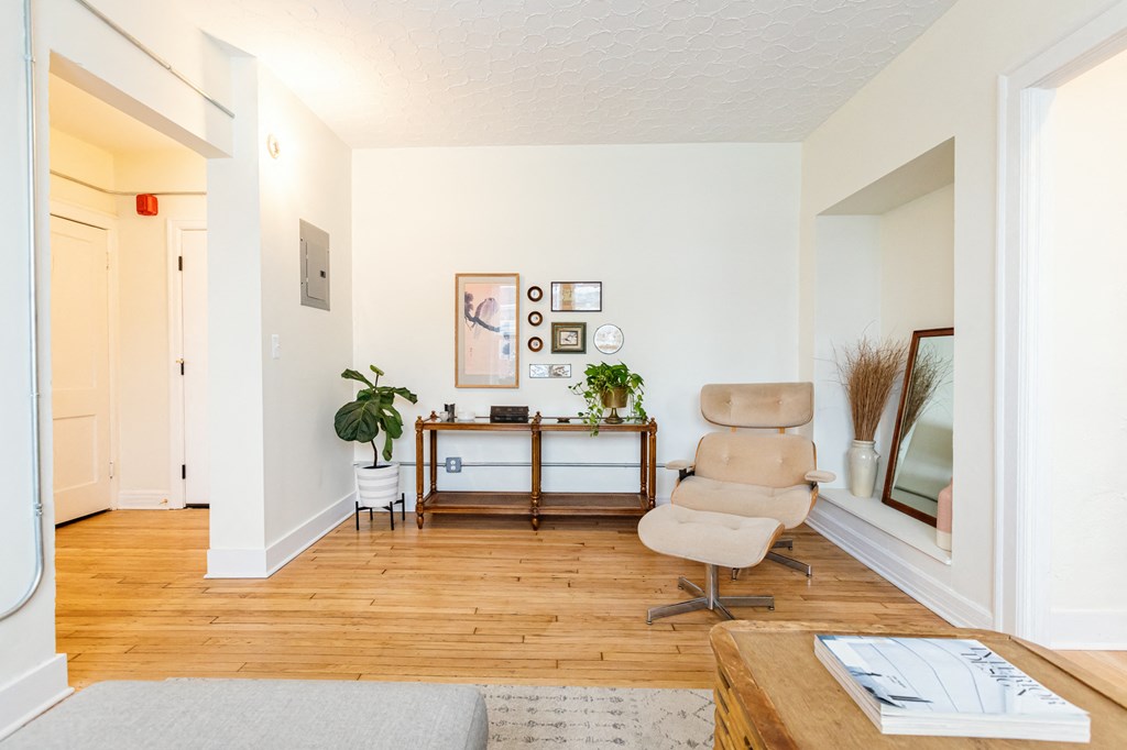 a living room with white walls and hardwood floors