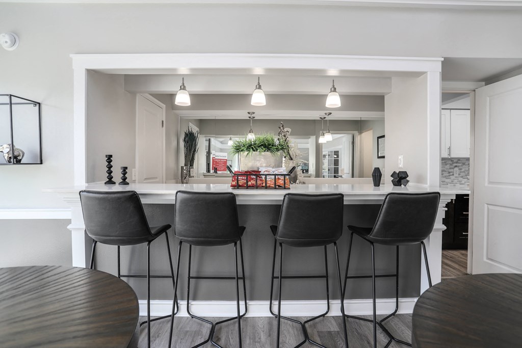 an open kitchen and dining area with bar stools in a house