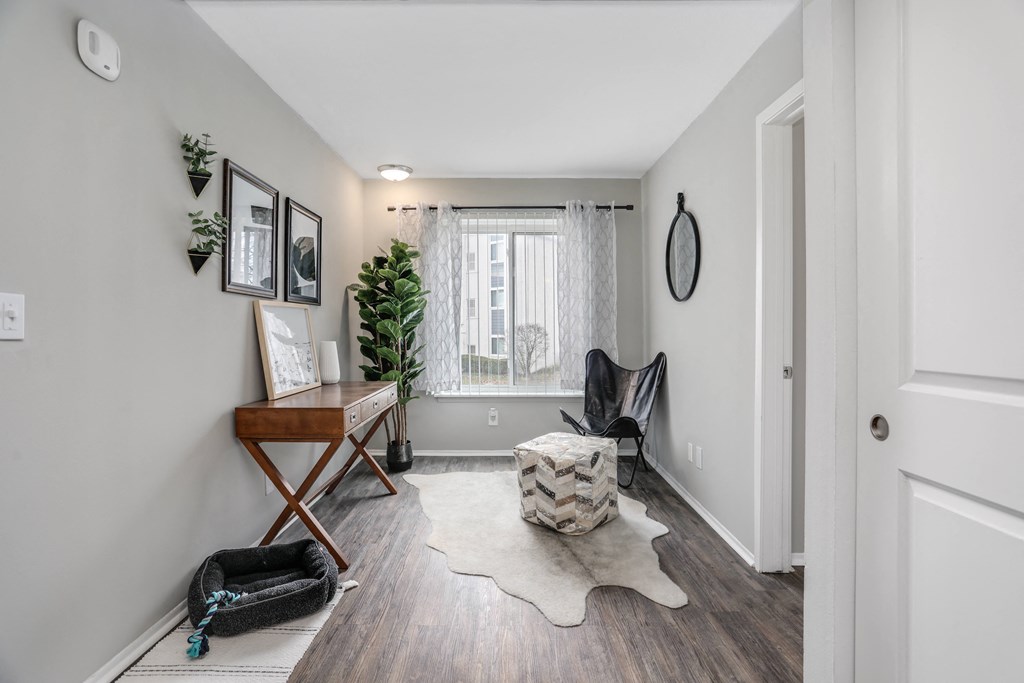 a living room with a chair and a desk and a window