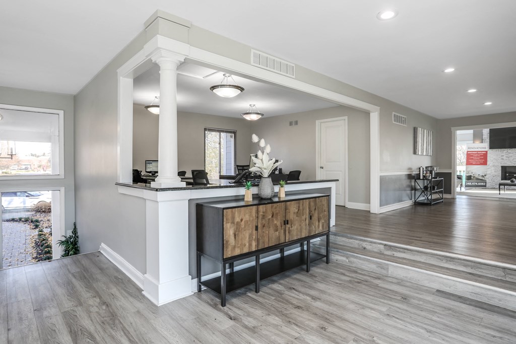 an open living room and kitchen with a large white counter top and a wood floor