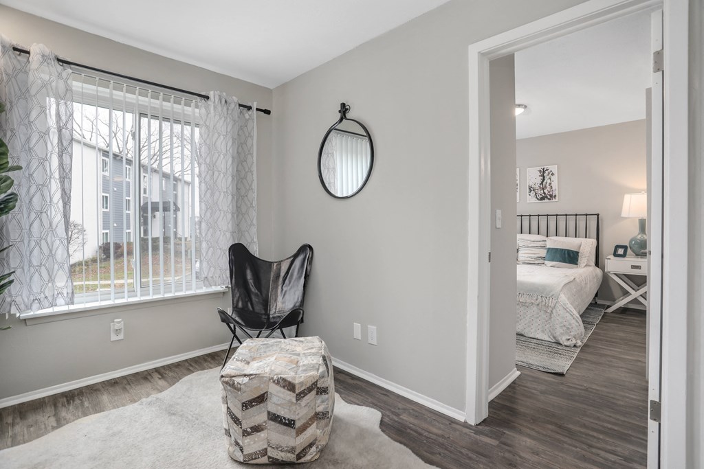 a bedroom with a large window and a chair in a room with a bedroom door