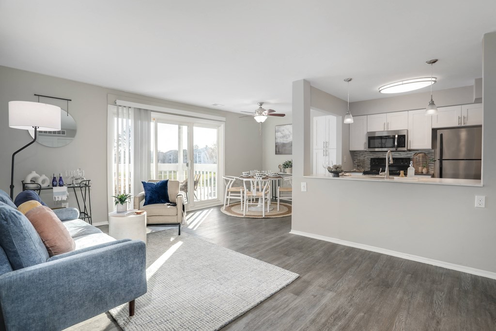 a living room with a couch and a chair and a kitchen