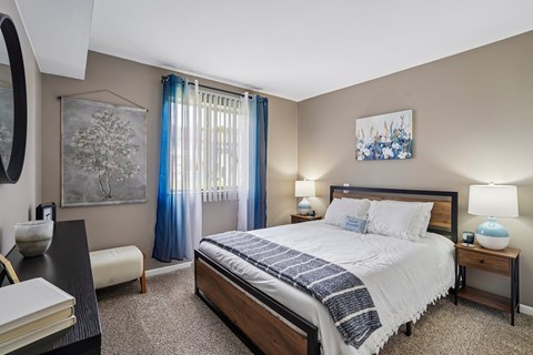 A bedroom with a large bed and a painting on the wall.