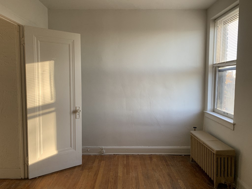 a room with a door and a radiator and a window