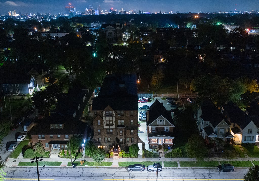 an aerial view of a neighborhood at night with the skyline in the background
