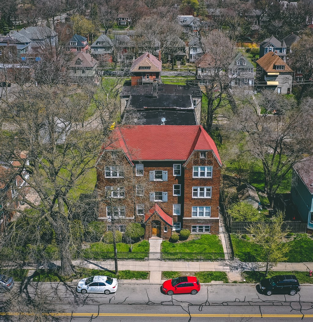 an aerial view of a brick building with a red roof