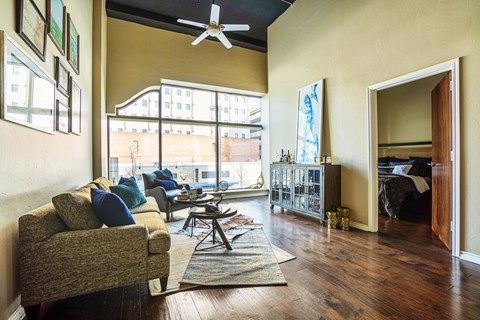 A living room with a couch and a fan.