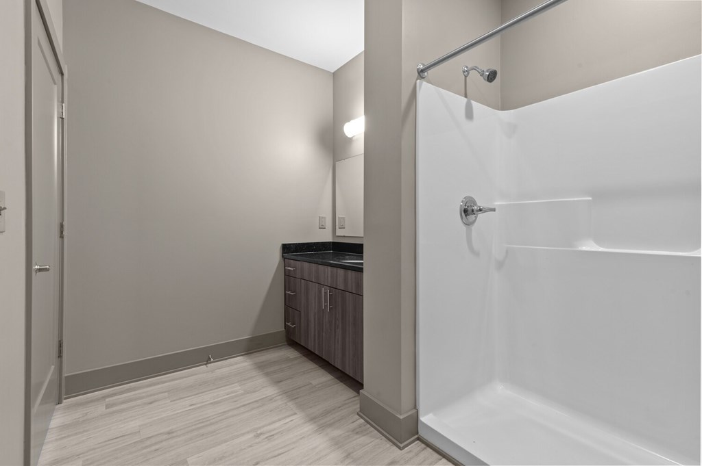 A white bathroom with a walk-in shower and a vanity.