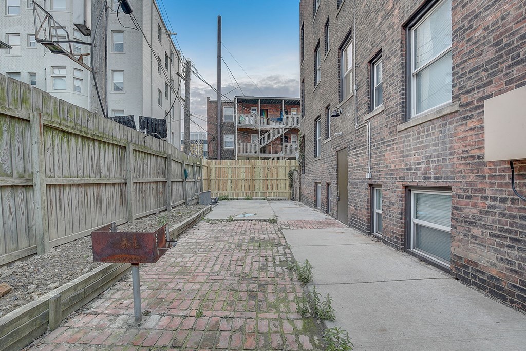 the alleyway between two brick buildings with a rusty mailbox