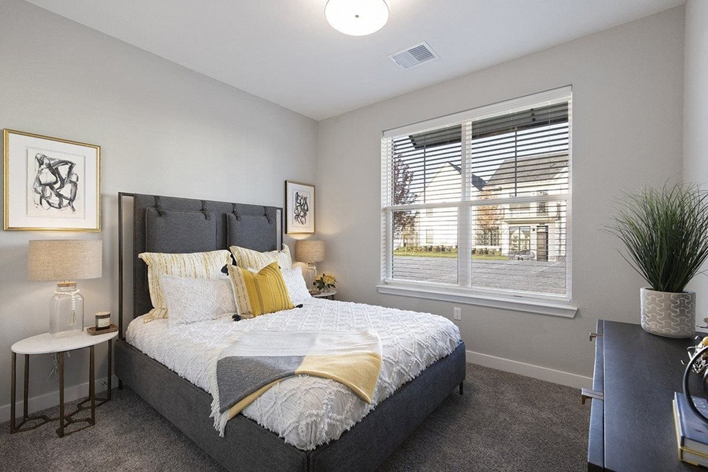 a bedroom with a large window and a bed