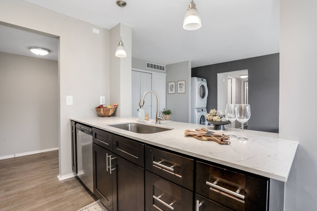 a kitchen with dark cabinets and a sink and a window