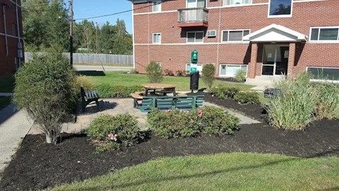 A small garden area in front of a brick building.
