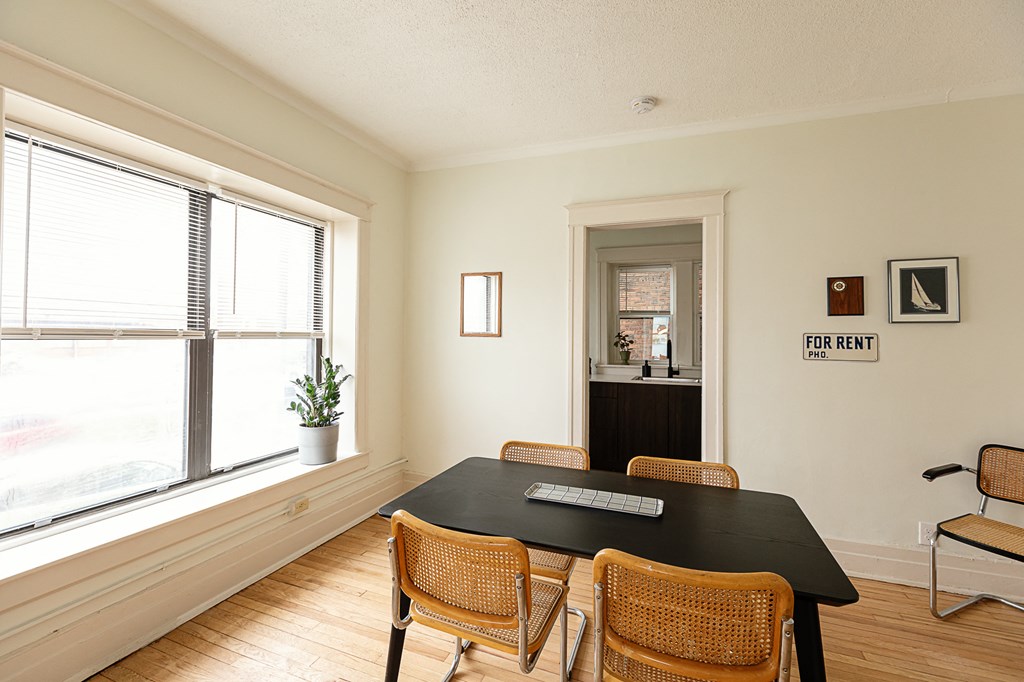 a dining room with a black table and rattan chairs