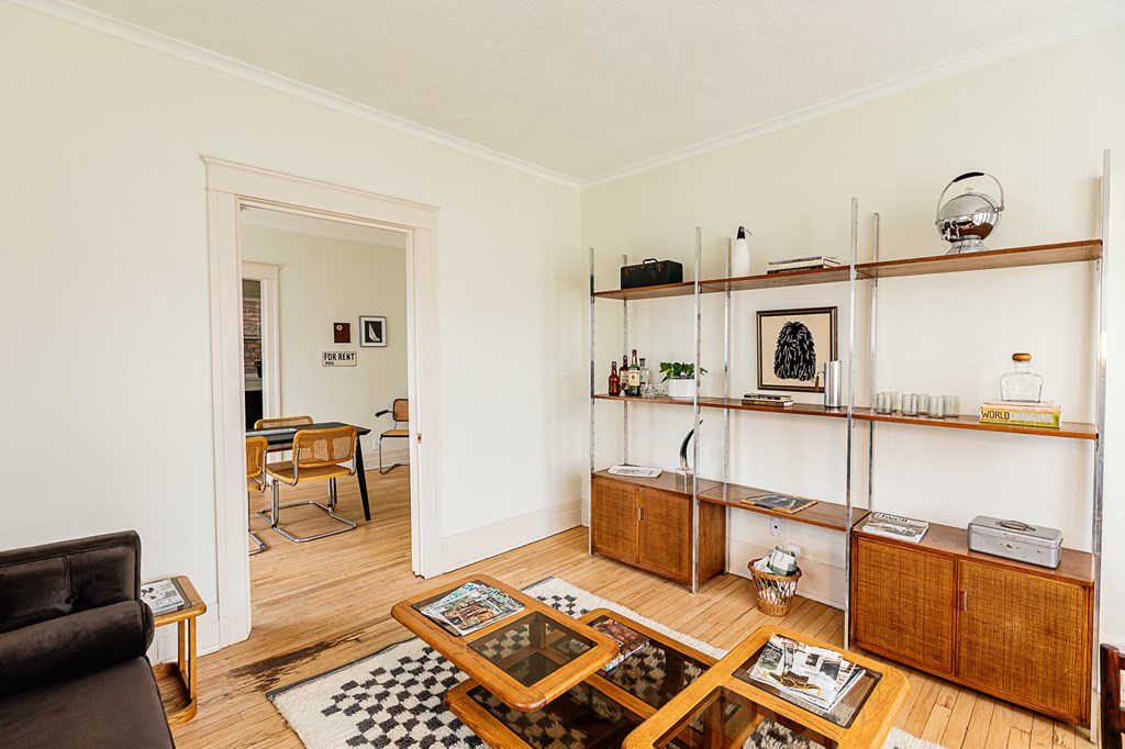 a living room with white walls and wooden floors
