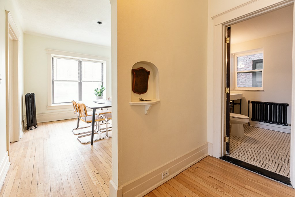 a dining room with a table and chairs and a bathroom in the background