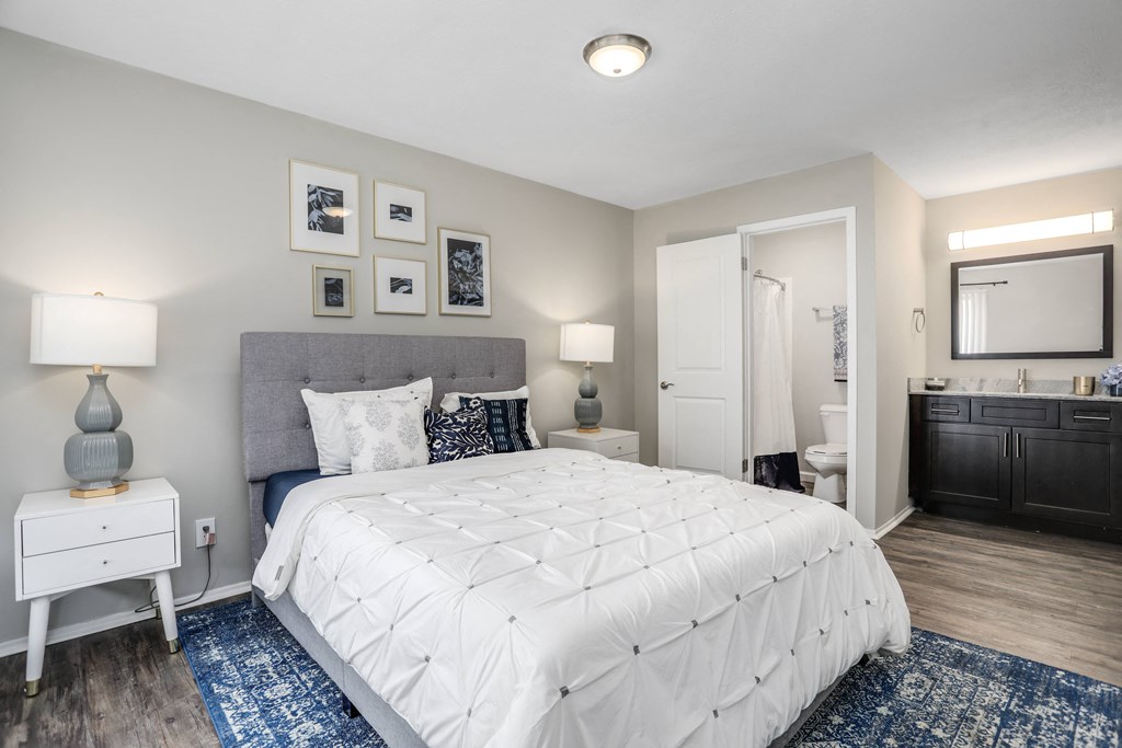 a white bedroom with a bed and a bathroom