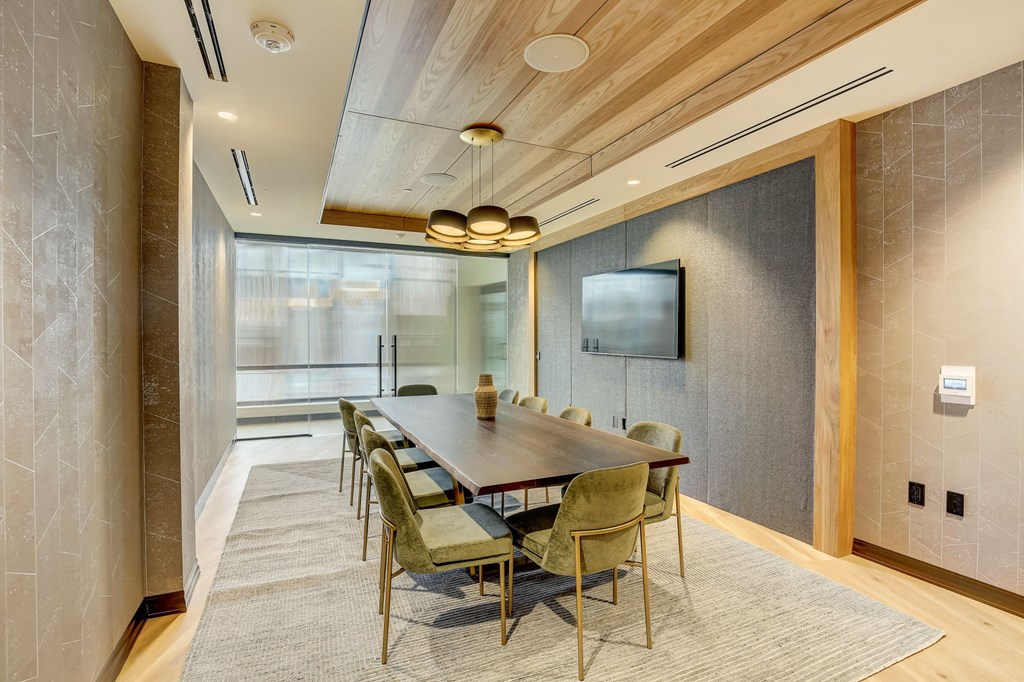 a conference room with a long table and chairs and a television