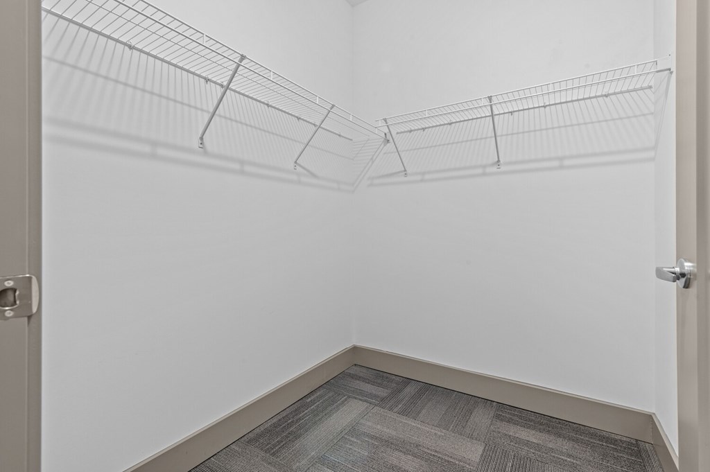 A white wall with a metal wire shelf attached to it.
