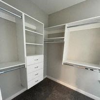 a white closet with shelves and a window
