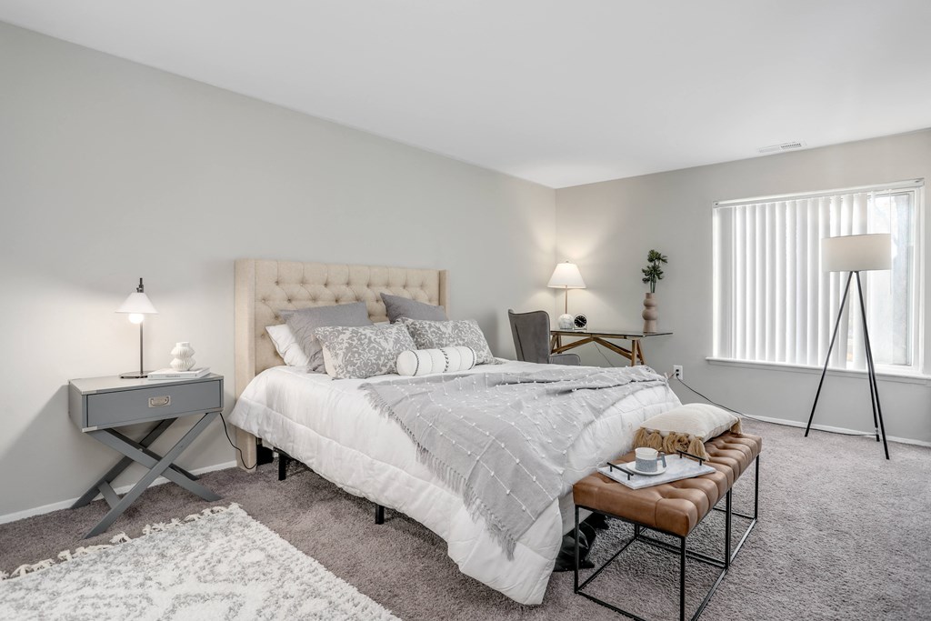 a bedroom with a bed and a night stand and a window