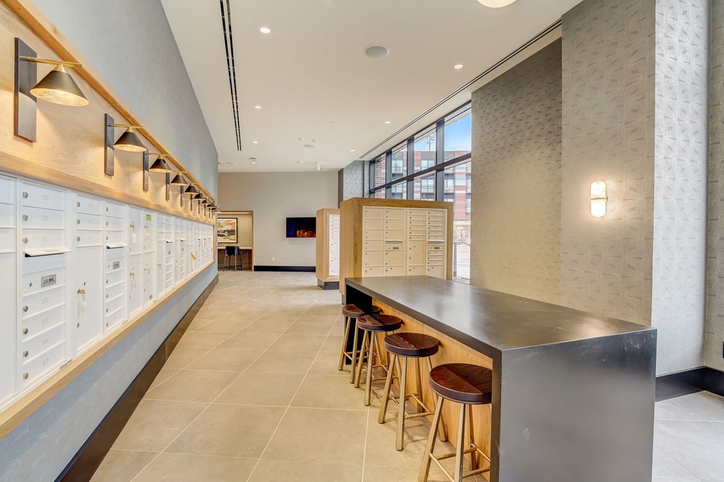 a long bar with stools in a room with cabinets and a window