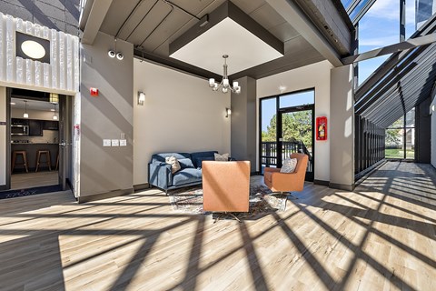 A modern living room with a blue sofa and orange chairs.