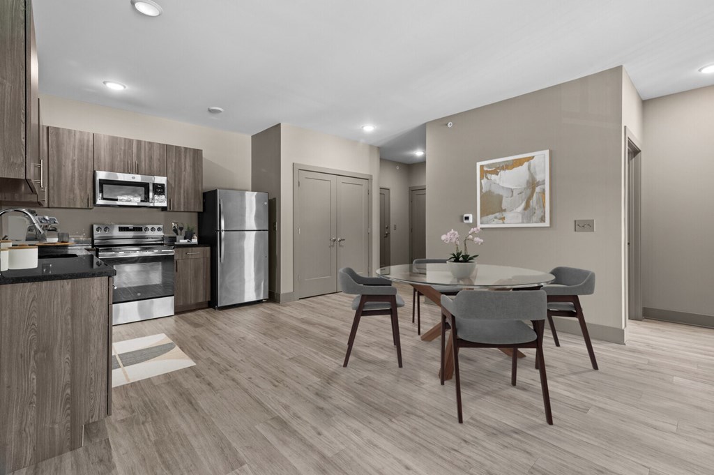 A modern kitchen with a dining table set for two.