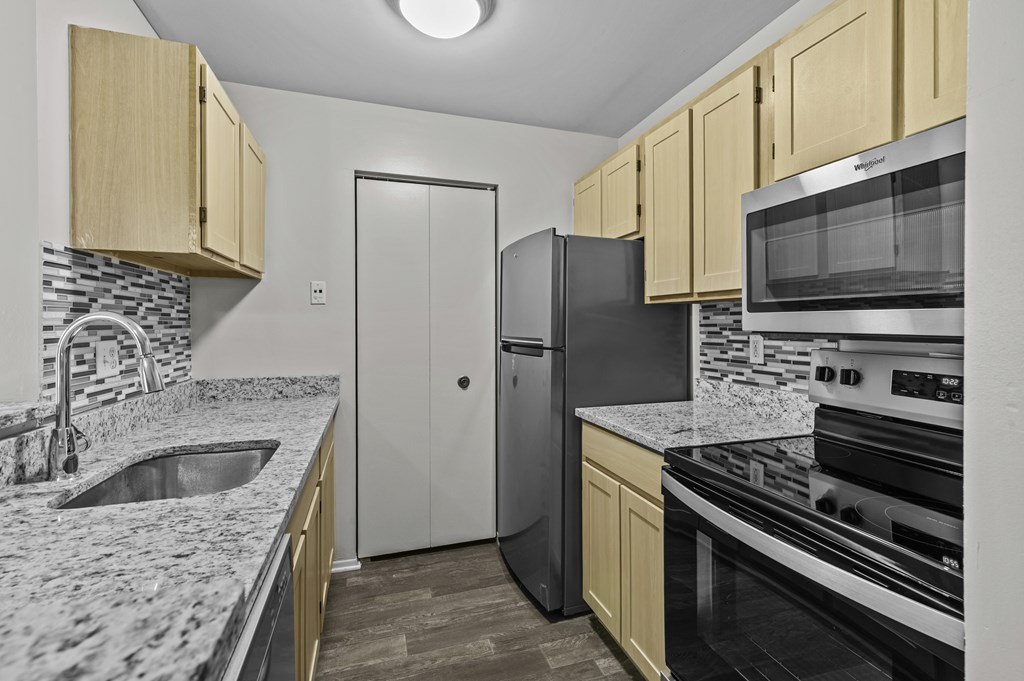 A kitchen with black appliances and wooden cabinets.