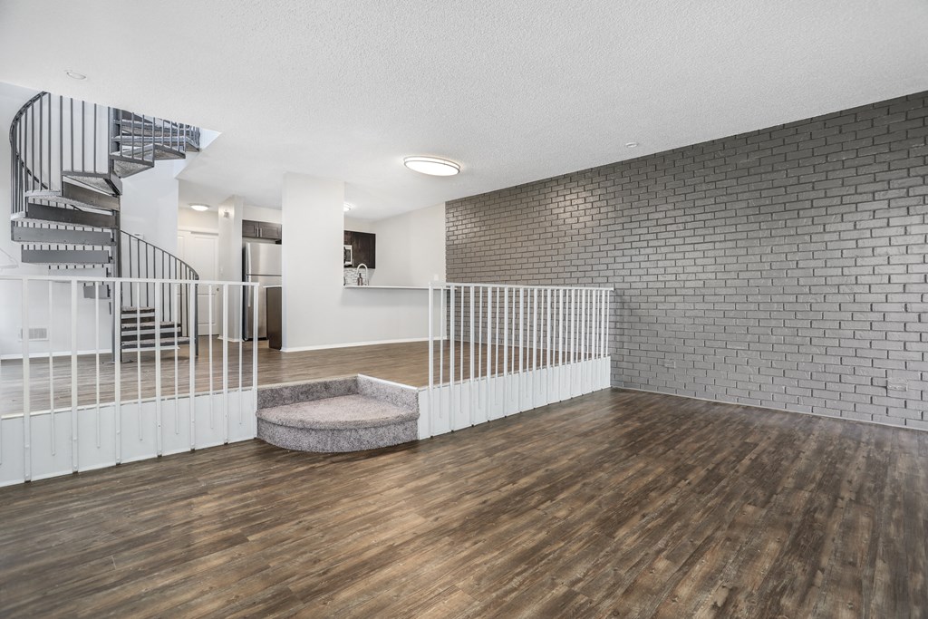 the living room of a house with wood floors and a staircase