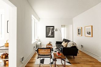 a living room with white walls and a black couch