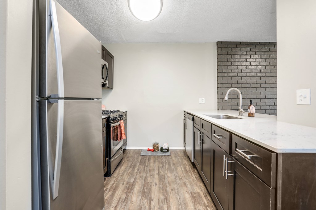a renovated kitchen with stainless steel appliances and a white counter top