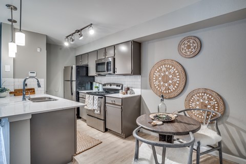A modern kitchen with a dining table and chairs.