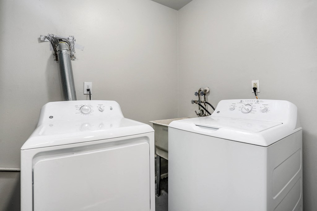 a white laundry room with two white washing machines