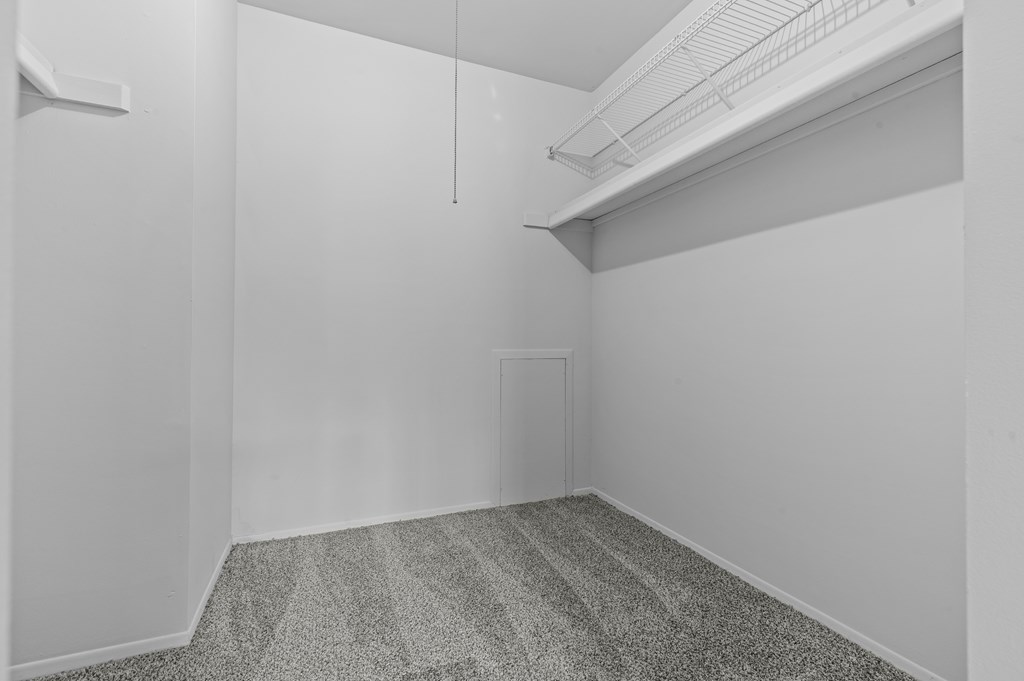 A room with a ceiling fan and a door on the right side.