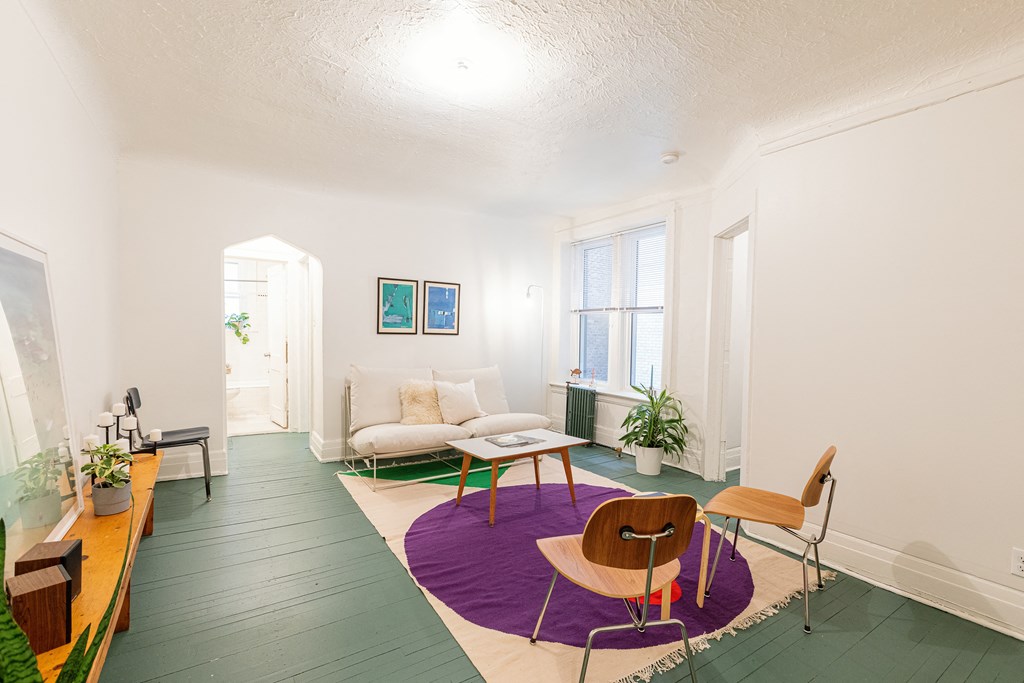 a living room with a white couch and a purple rug
