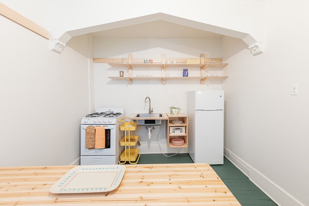 a kitchen with a wooden floor and a stove and refrigerator