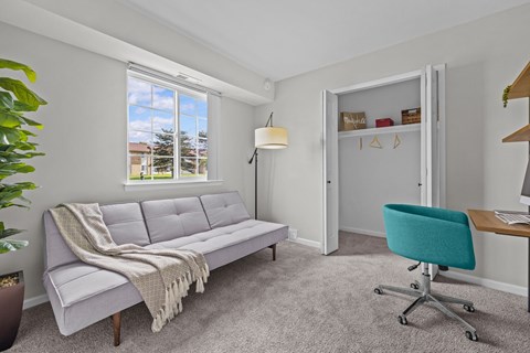 A living room with a grey couch and a green chair.