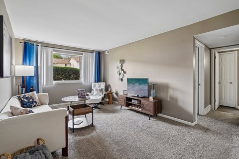 A living room with a white couch and a television.