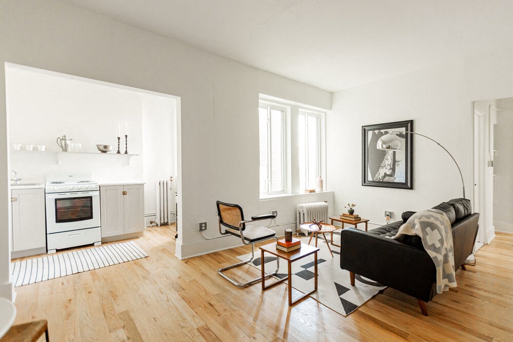 a living room with white walls and hardwood floors