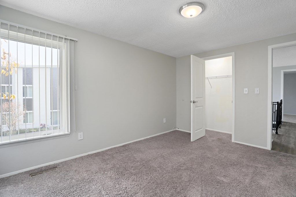an empty living room with a large window and a door