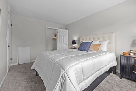 A bedroom with a large bed and a nightstand.