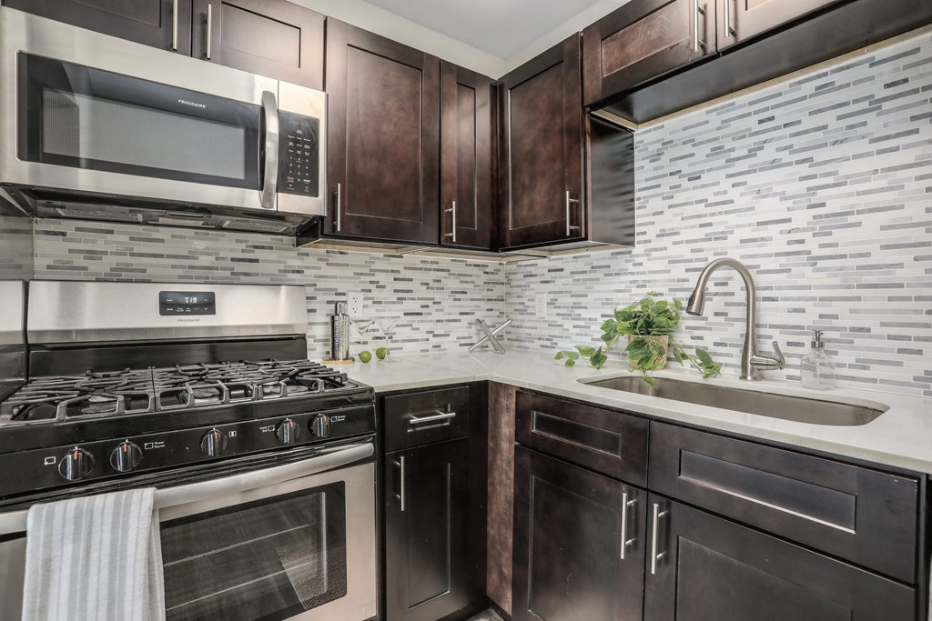 a kitchen with a stove and a sink and a microwave