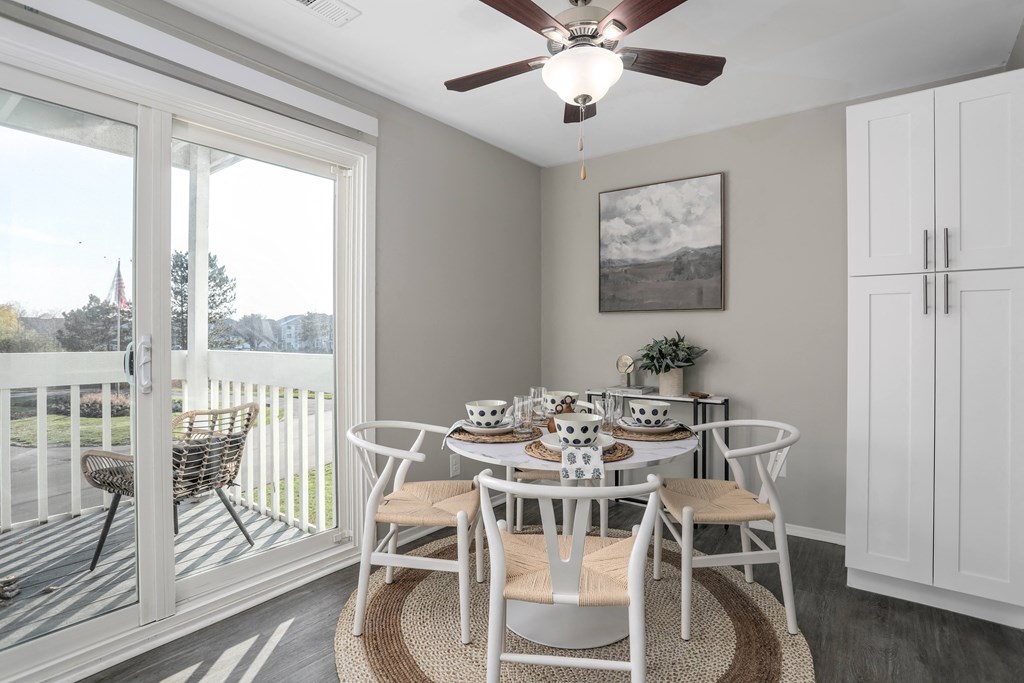 a dining room with a table and chairs and a ceiling fan