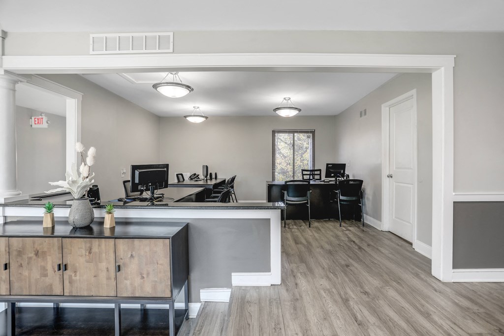 an office space with a desk and chairs and a counter and a window