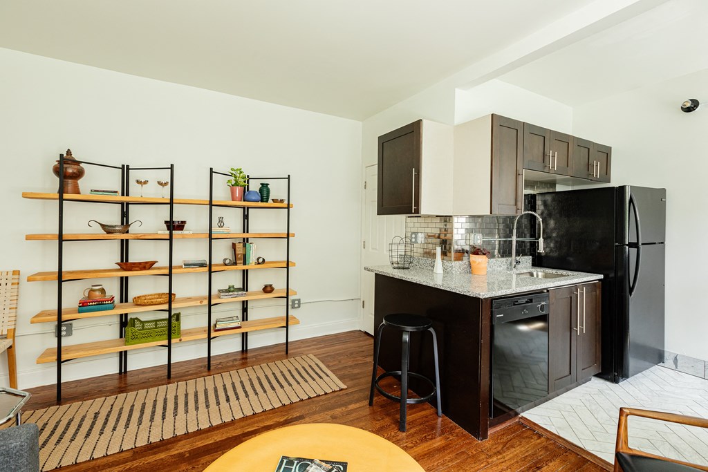 a kitchen with a black refrigerator freezer next to a black stove top oven