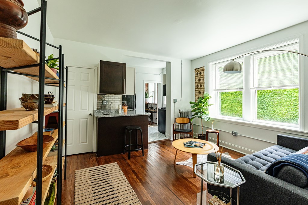 a living room with a kitchen in the background and a couch and table in the foreground