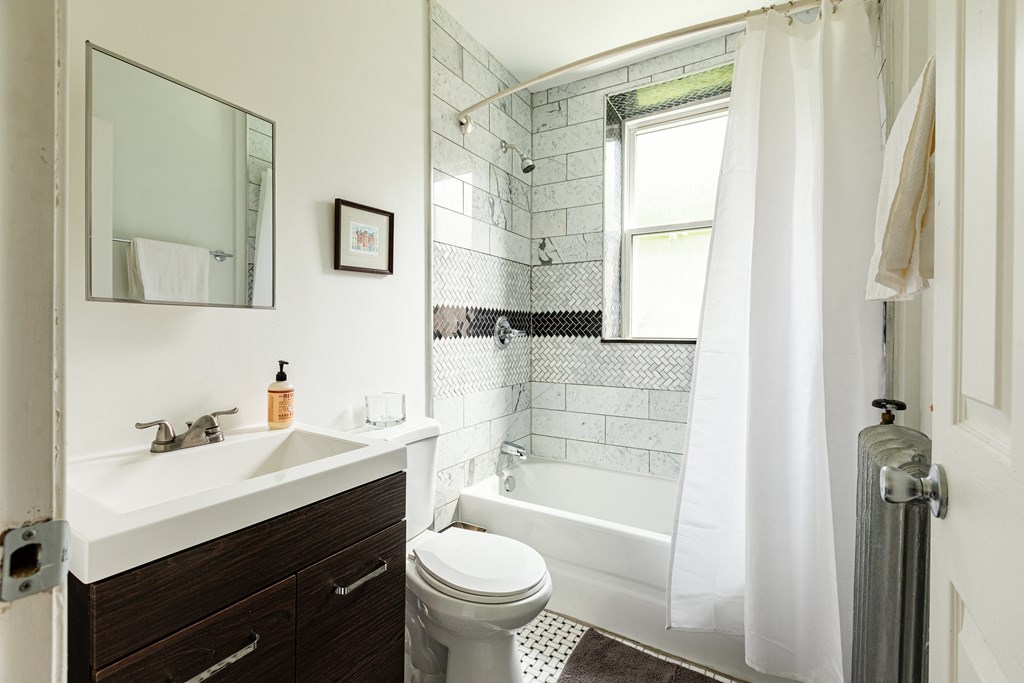 a bathroom with a white sink and toilet next to a bathtub with a shower curtain