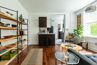 a kitchen and living room with white walls and wood floors